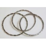 A set of three sterling silver slave bangles, c.1970, by R G Hounslow, each flat section bangle with