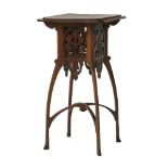 An Art Nouveau oak lamp table, the stepped top, over a pierced basket with stylised motifs, on