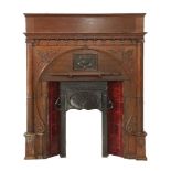 An Art Nouveau oak fireplace, in the classical taste, centred with an embossed copper plaque, the