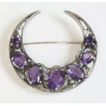 A silver Arts and Crafts amethyst crescent brooch, attributed to Bernard Instone, a graduated