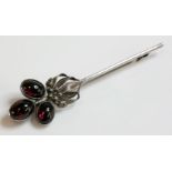 A silver Arts and Crafts garnet bar brooch, attributed to Bernard Instone, a trefoil cluster of