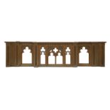 A Victorian 'Gothic' pitch pine breakfront carved altar front, with pierced arches, carved