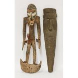 A West African carved wooden standing figure, on half moon stand with conch shell inset eyes, 72cm