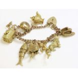 A gold curb link charm bracelet, marked 9ct, hung with seven 9ct gold charms, including a corgi