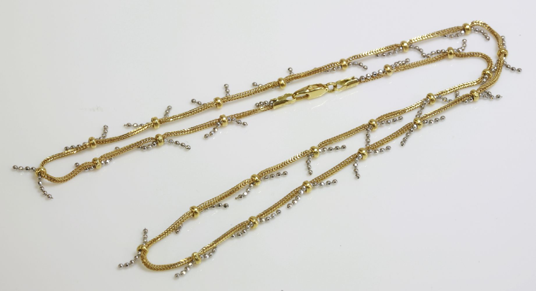 An Italian gold chain, by UNOERRA, of yellow fox tail chain with white gold faceted plug chain