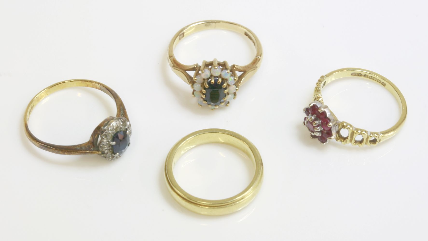 A 9ct gold sapphire and opal cluster ring, an 18ct gold ruby cluster ring, a sapphire and diamond