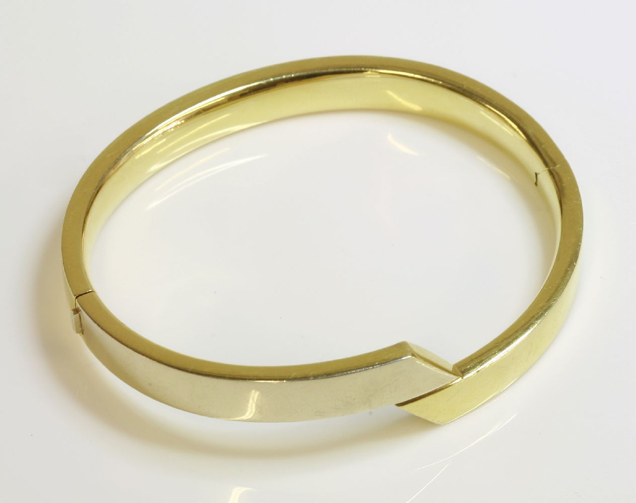 An 18ct gold two colour hinged bangle