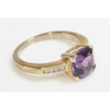 A 9ct gold single stone amethyst ring, with channel set diamond shoulders