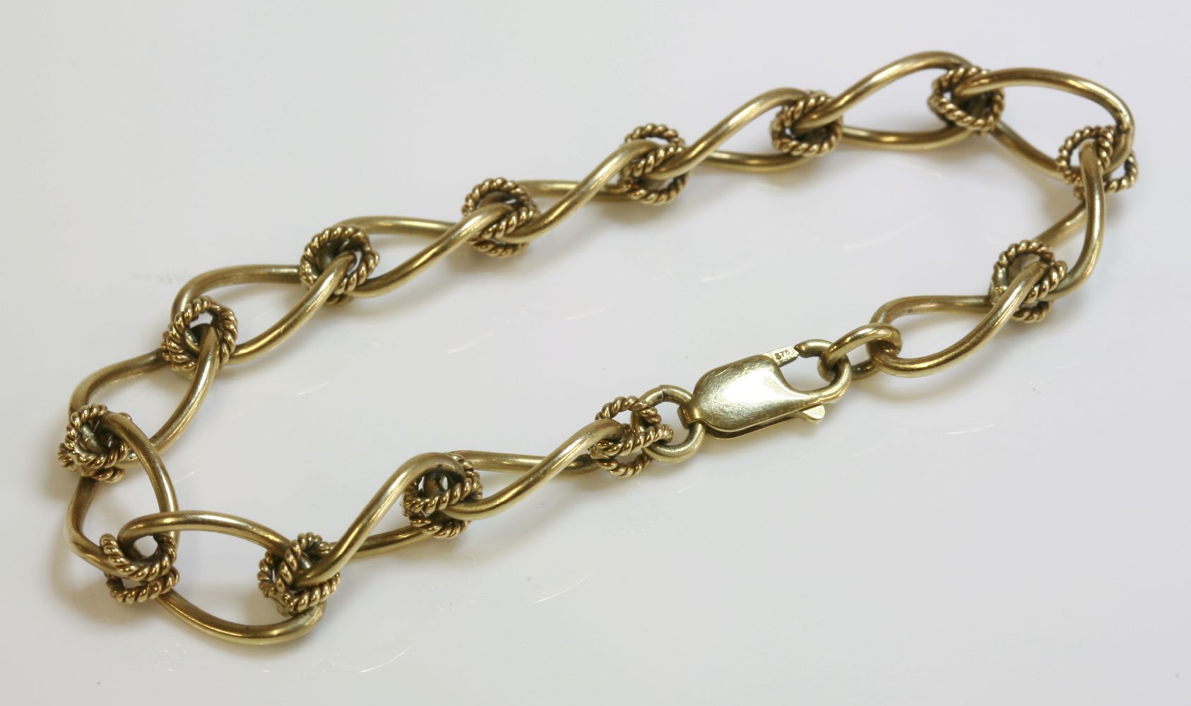 A 9ct gold open curb and twisted wire link bracelet