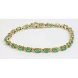 An emerald and diamond gold line bracelet, marked 14K