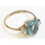 An aquamarine and diamond three stone ring, with an oval mixed cut aquamarine and two brilliant