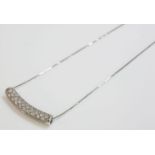 A white gold curved bar slider pendant, pav‚ set with cubic zirconia, marked 750