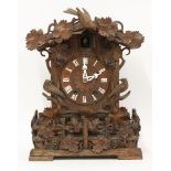 A 'Black Forest' cuckoo clock,with carved oak birds, vines and fencing,46cm high