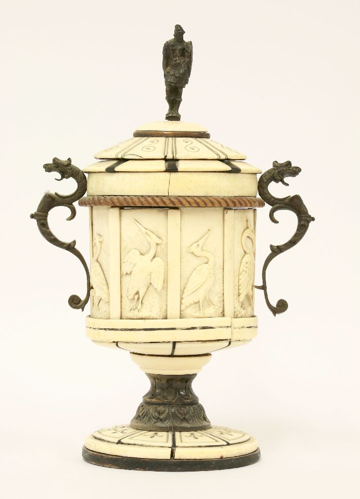 An Italian ivory and horn cup and cover,    with bronze mounts and seven panels of storks, damaged,