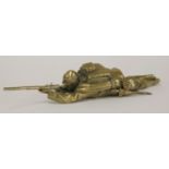 A brass inkwell,c.1900, in the form of a soldier, probably French, lying on his stomach aiming his