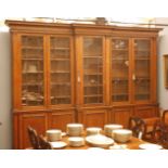 A Victorian oak breakfront bookcase,the cornice over glazed cupboards, enclosing adjustable shelves,