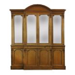 A Victorian light oak breakfront bookcasewith an arched cornice and glazed upper doors, the base