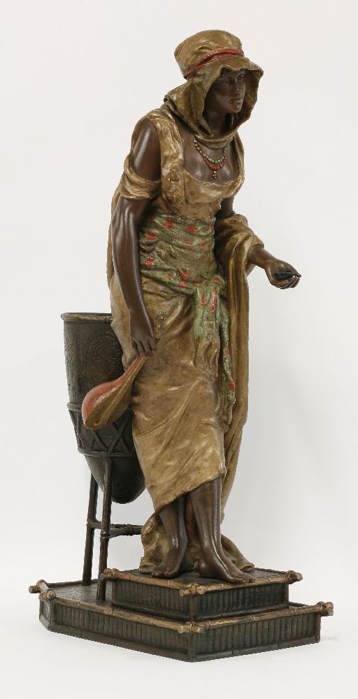 A spelter figure of an Arab girl,standing beside a brazier holding a lute and a dish, signed 'L