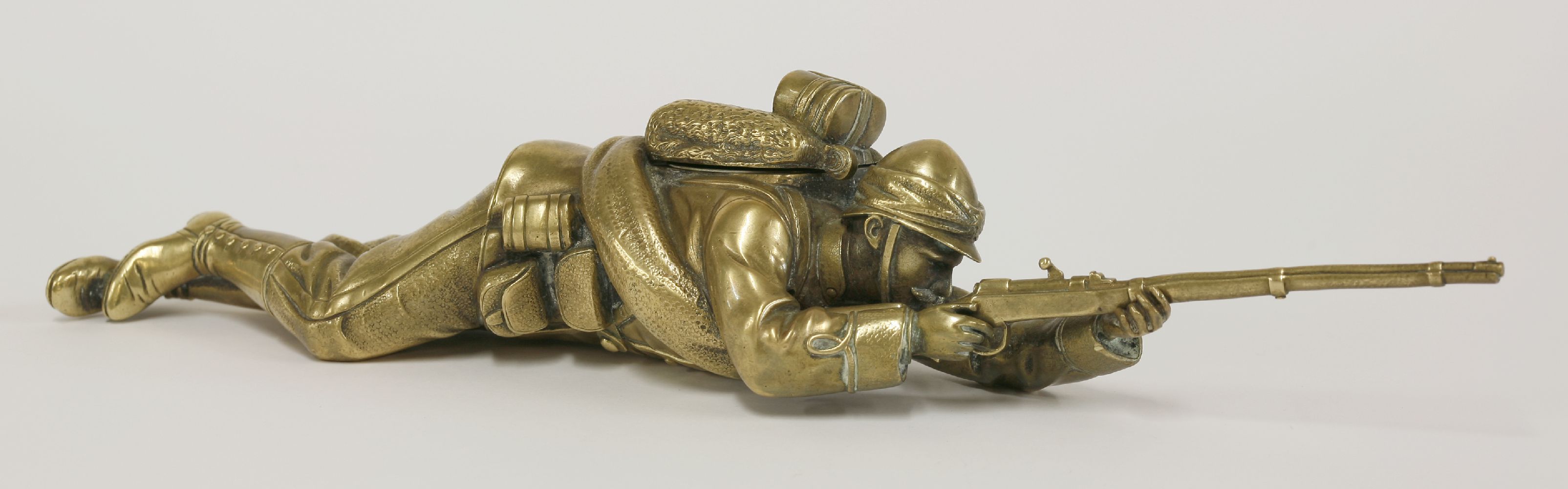 A brass inkwell,c.1900, in the form of a soldier, probably French, lying on his stomach aiming his - Image 2 of 4