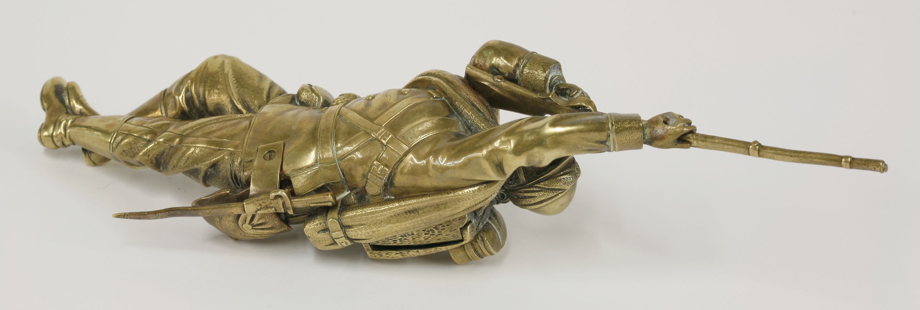 A brass inkwell,c.1900, in the form of a soldier, probably French, lying on his stomach aiming his - Image 3 of 4