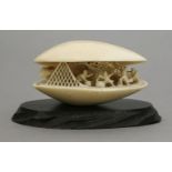 An ivory Shell Dream, late 19th century, the partly-opened bivalve carved on the interior with pine,