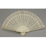 A carved bone Fan, c.1870, intricately pierced with repeating patterns, 32.5cm open, 19cm guard
