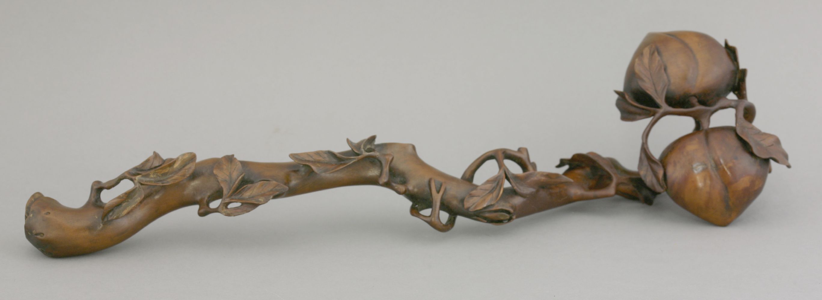 A boxwood ruyi Sceptre, possibly 18th century, intricately carved as two peaches on a gnarled