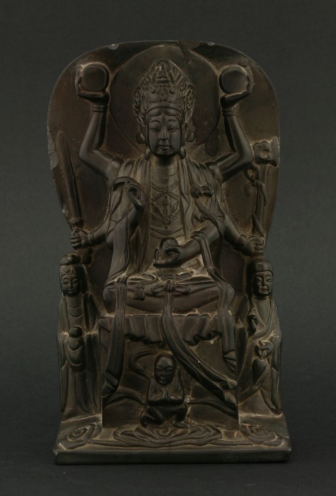 A finely carved and polished Guanyin, possibly 18th century, seated cross-legged on a high plinth,