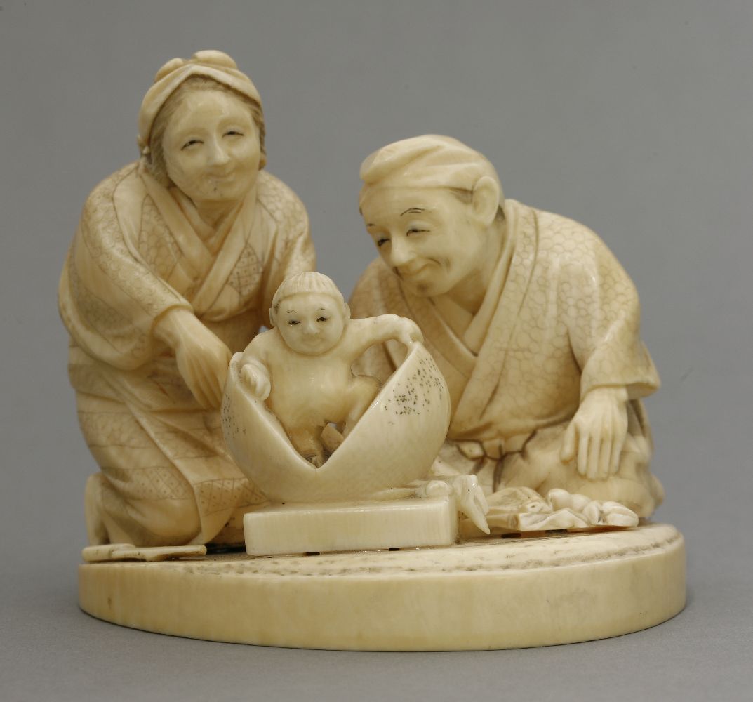 An attractive ivory Okimono, c.1880, of Momotaro, the Peach Boy arising from the fruit watched by