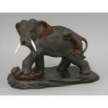 A bronze Elephant, late 19th century, the pachyderm with flailing ears and ivory tusks, a tiger on