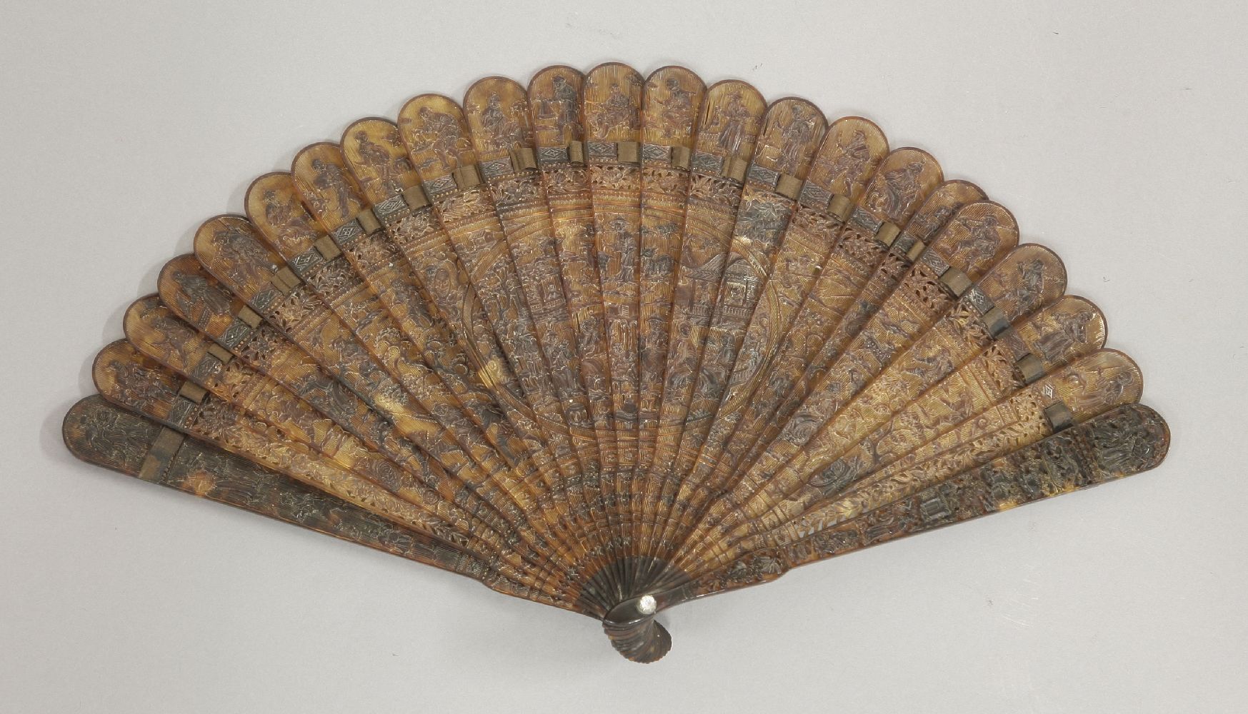 A finely carved Canton tortoiseshell brisé Fan, c.1810, with numerous figures at various pursuits in