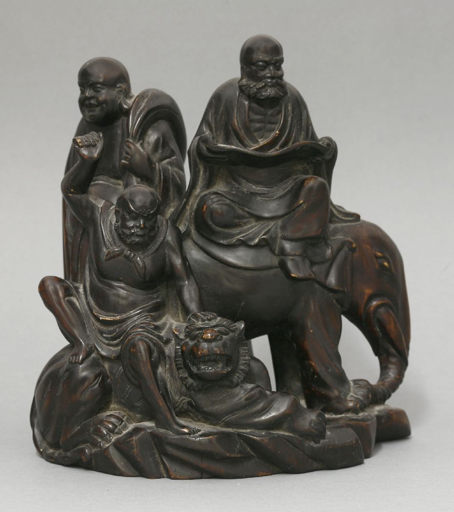 An unusual wood Group of three Buddhist Immortals, c.1900, one bearded and reading a sutra, and