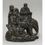 An unusual wood Group of three Buddhist Immortals, c.1900, one bearded and reading a sutra, and
