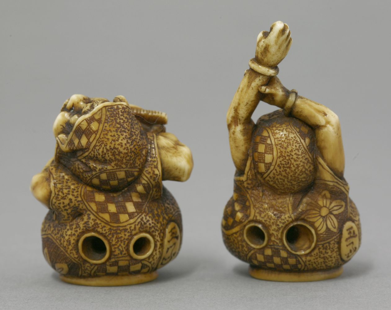 A rare and fine pair of ivory Netsuke, mid 19th century, one of Daruma stretching his arms above his - Bild 2 aus 3