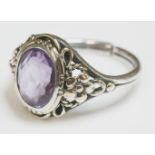 An Arts and Crafts silver and gold amethyst ring,possibly by Bernard Instone, an oval mixed cut