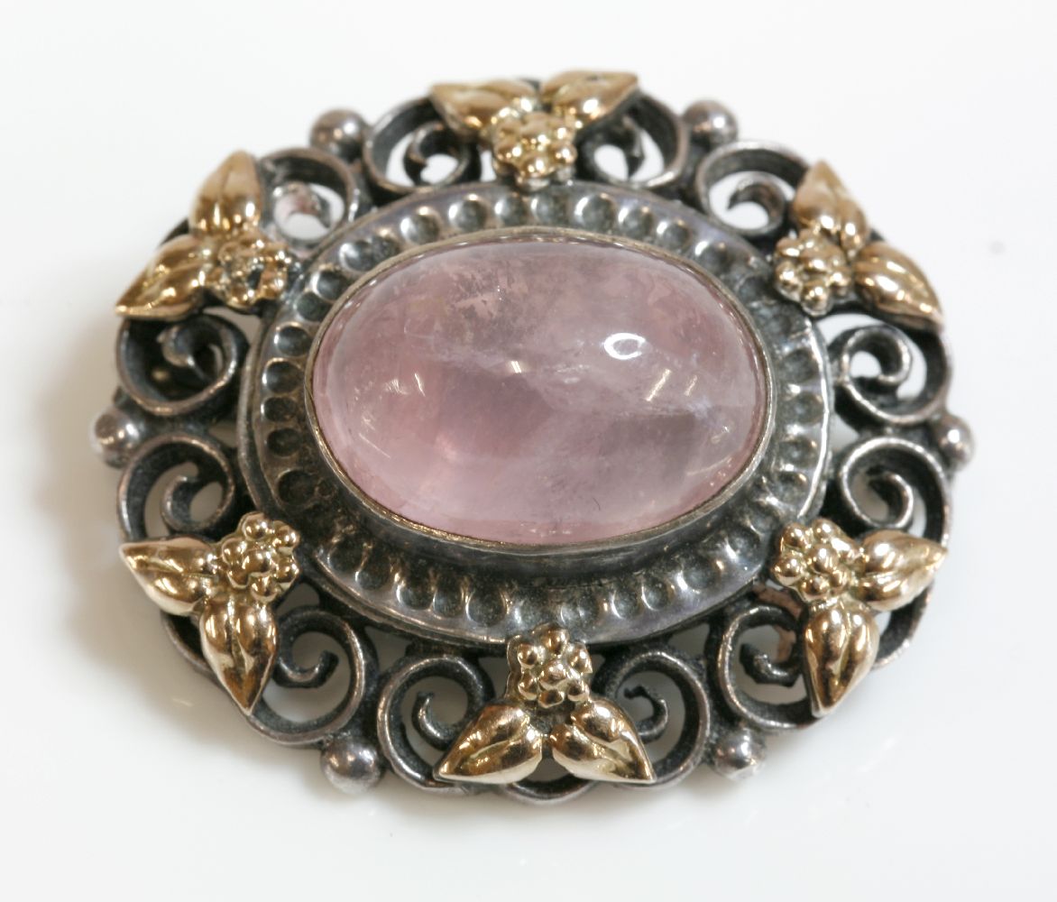 An Arts and Crafts silver and gold, rose quartz brooch,attributed to Bernard Instone, an oval rose