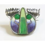 A German Jugendstil silver and enamel brooch,with a circular green paste cabochon, a central