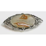 An Arts and Crafts agate brooch,attributed to Bernard Instone.  An oval agate plaque, four claw