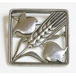 A sterling silver brooch by Georg Jensen,no. 250, with a pair of birds perched at either side of