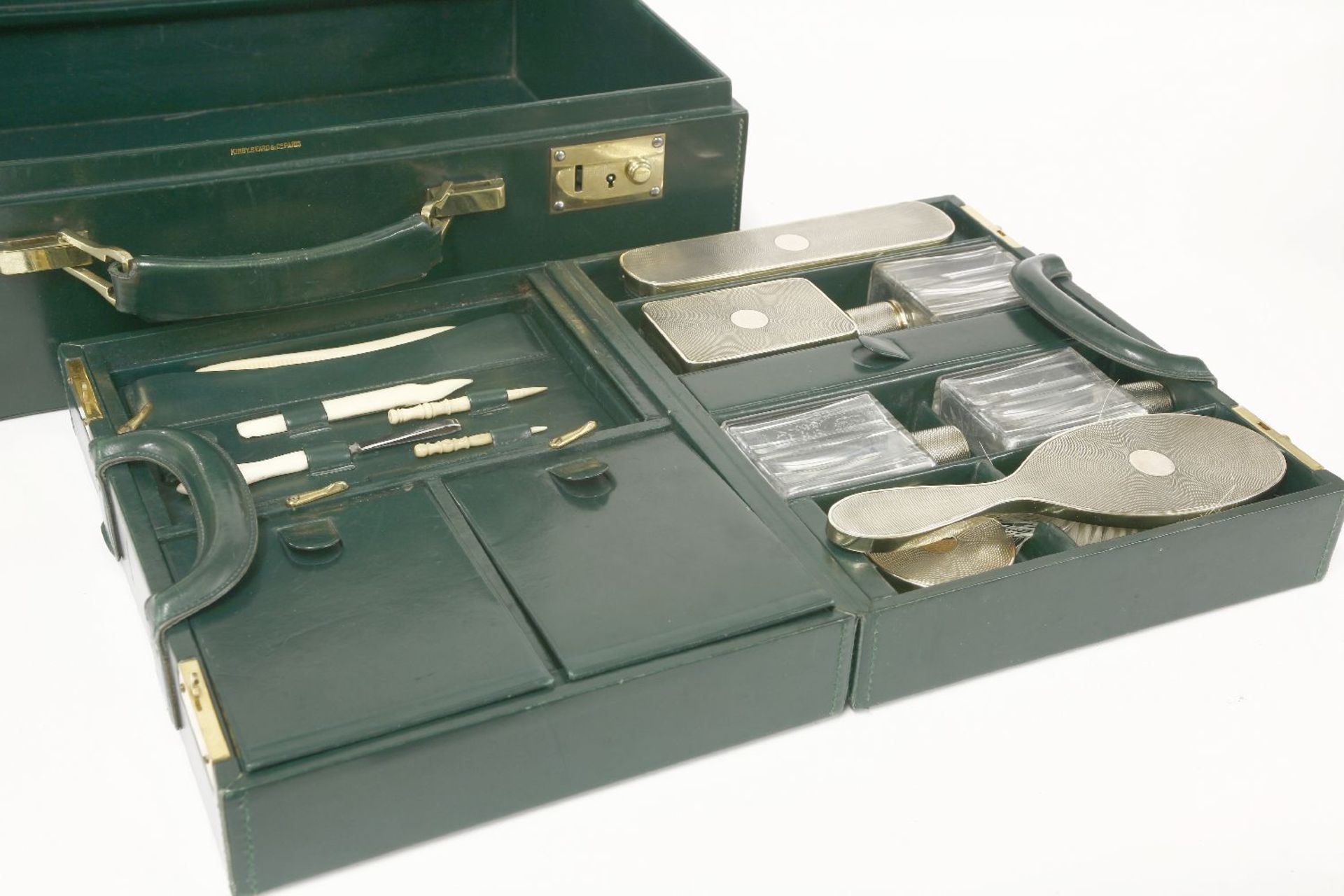 A green leather dressing case,the fitted interior with French silver-gilt mounted glass jars and - Image 2 of 2