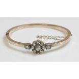 A late Victorian diamond set bangle, c.1900,with a circular cluster of nine old European cut