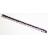 An Art Deco amethyst and diamond line bracelet,with a central row of rectangular step cut amethysts,