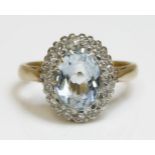 An aquamarine and diamond oval cluster ring,with a central oval mixed cut aquamarine, surrounded