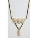 A carved coral gold necklace,with a centrepiece of three carved, angel skin, winged cherubs to a