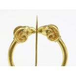 An Archaeological Revival gold penannular brooch, c.1870,with a pair of ram's head terminals to a