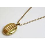 A Victorian gold locket and chain,the oval hinged locket with raised vertical bands with applied