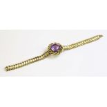 A Victorian amethyst and gold bracelet,with a centrepiece composed of a circular mixed cut amethyst,