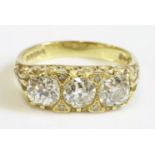 An 18ct gold three stone diamond carved head ring,with diamond set points.  A central old European