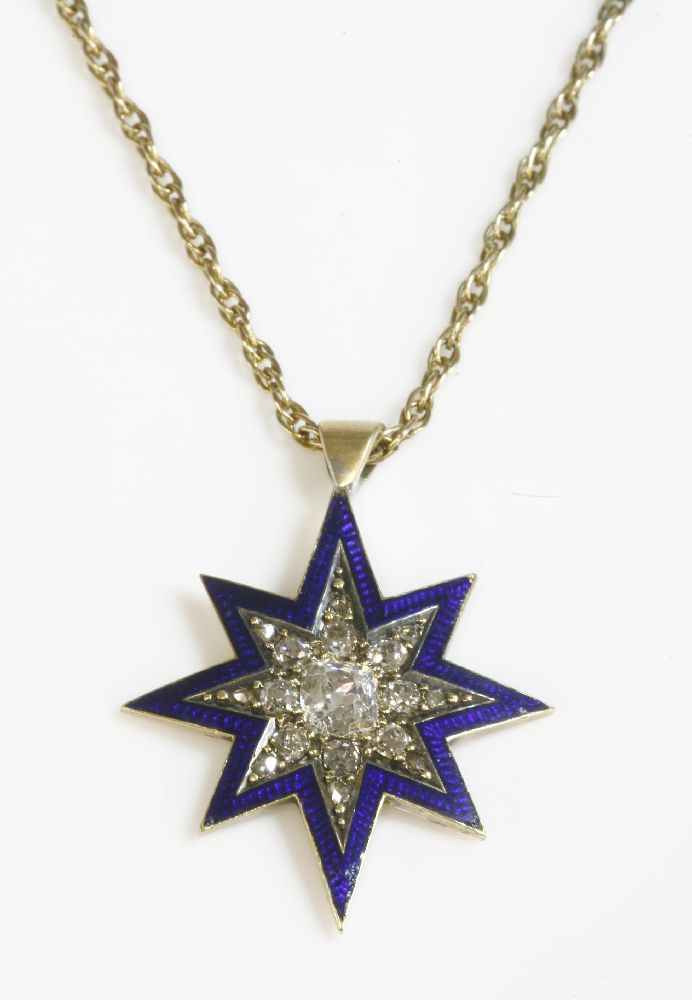 A diamond and enamel Indian star pendant,with a central cushion cut diamond, with graduated Swiss