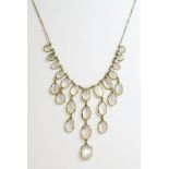 An 18ct gold moonstone fringe necklace,by Chroussis.  A centrepiece of graduated oval cabochon